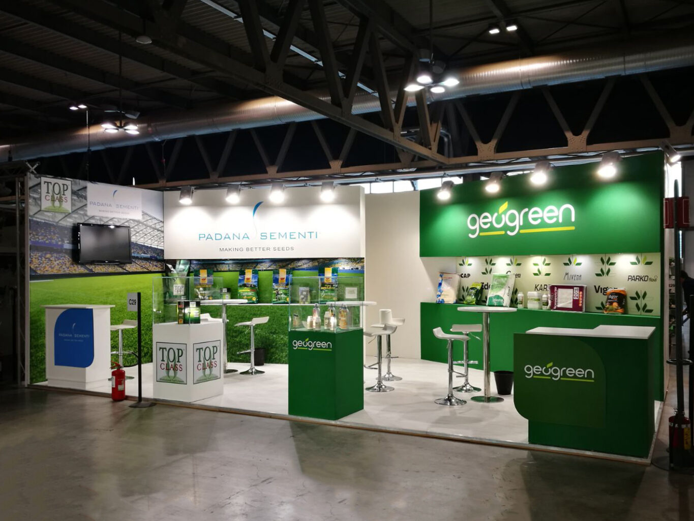 a green and white booth with white tables and green walls