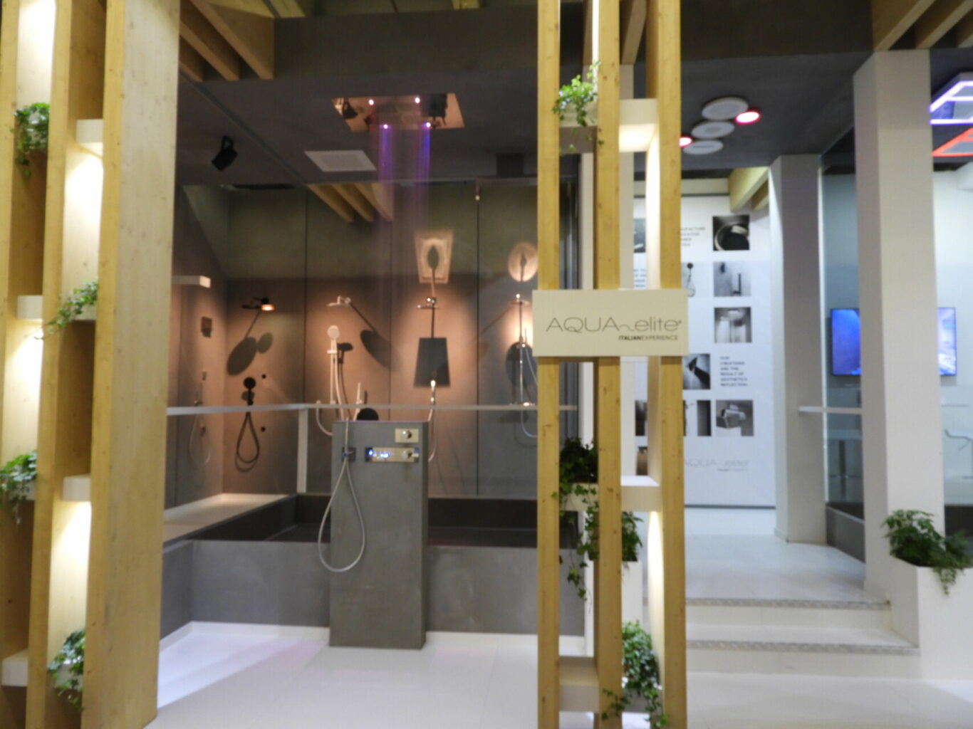 a shower with a glass wall and a wood pillar