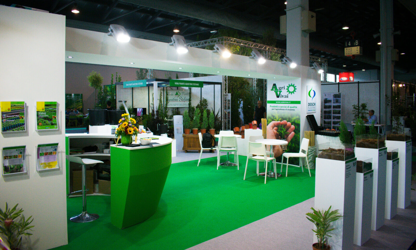 a green and white booth with white tables and chairs