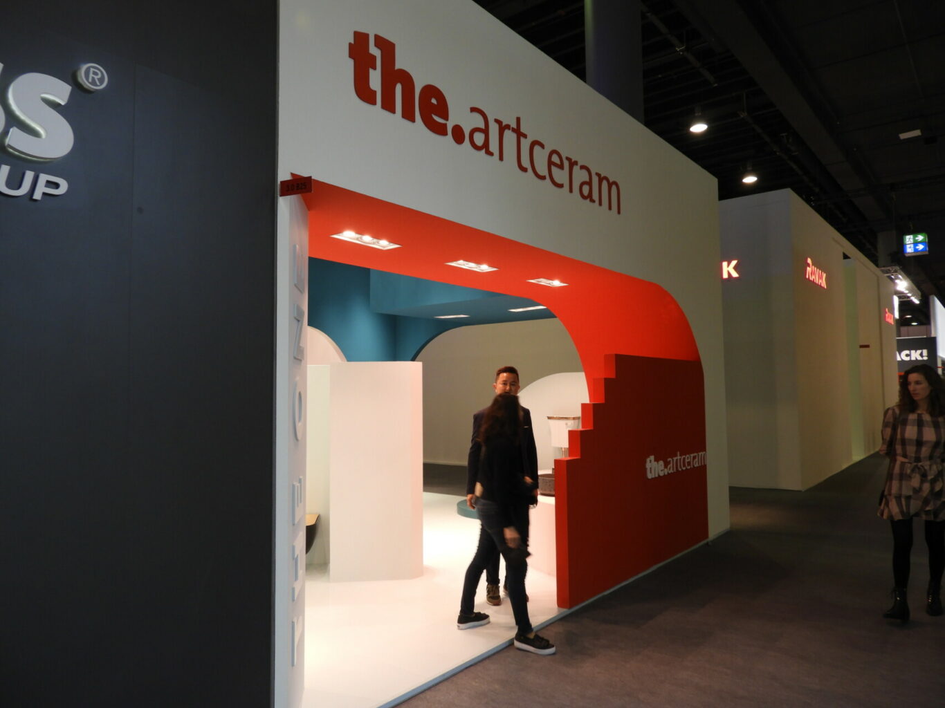 a man and woman standing in front of a white and red wall