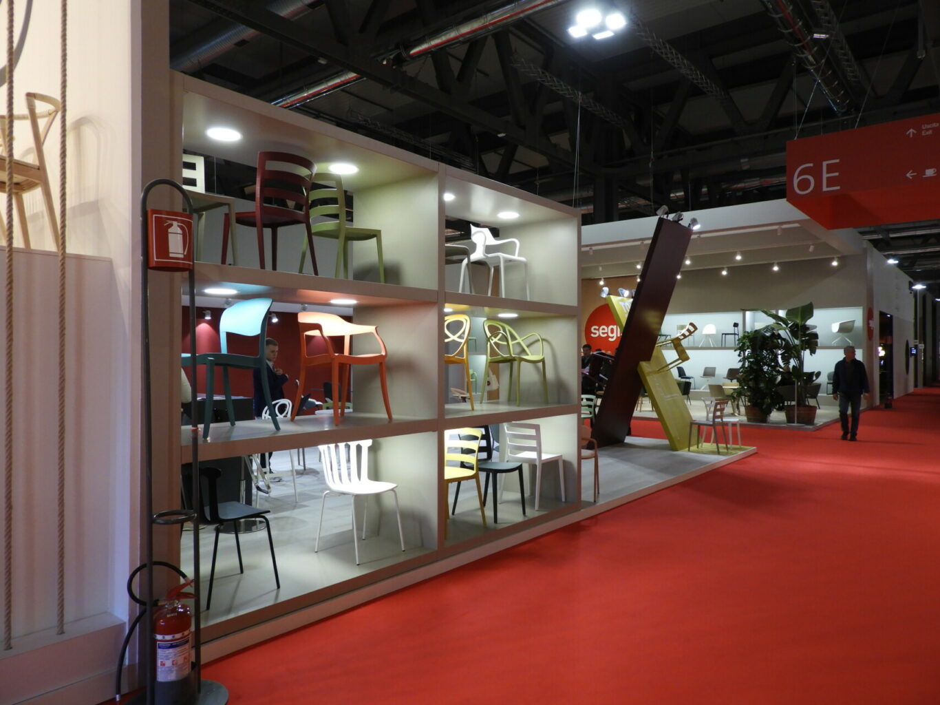 a room with shelves with chairs and a red carpet