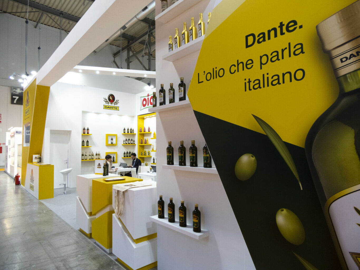 a yellow and white display with bottles of olive oil