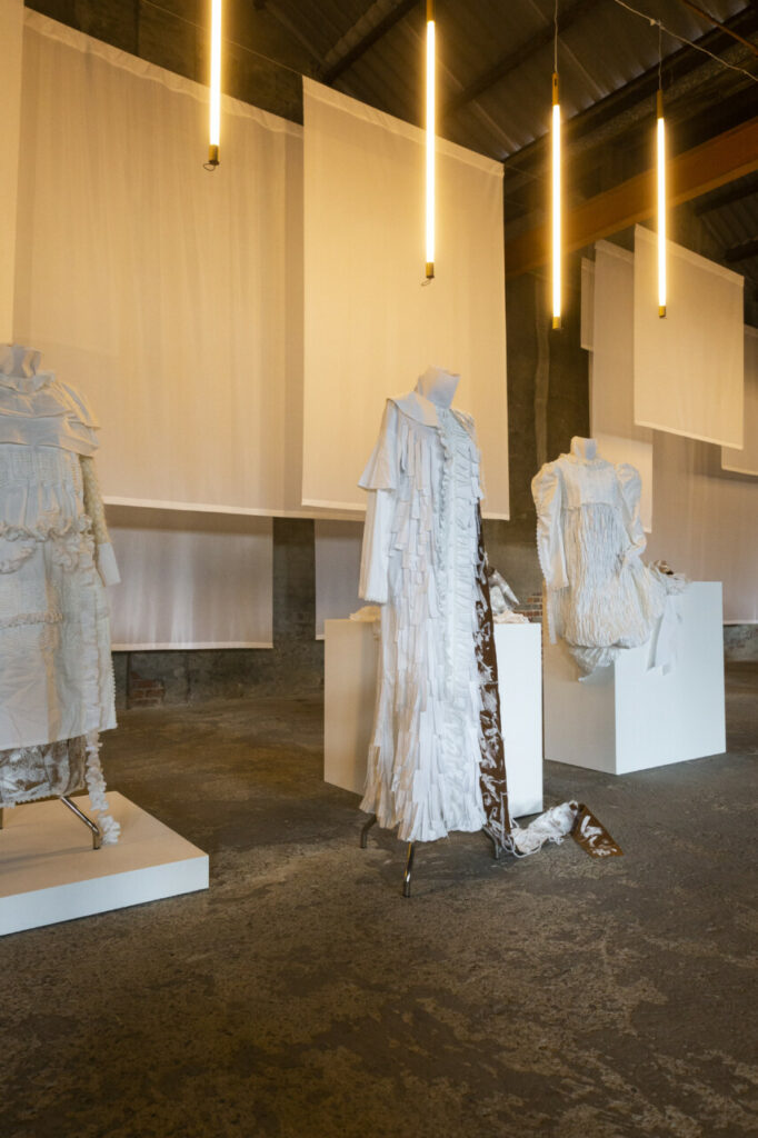 mannequins in a room with white cloth from ceiling