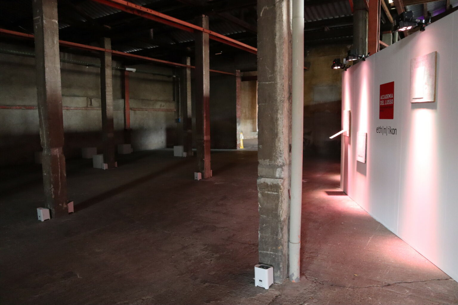 a concrete room with pillars and a sign