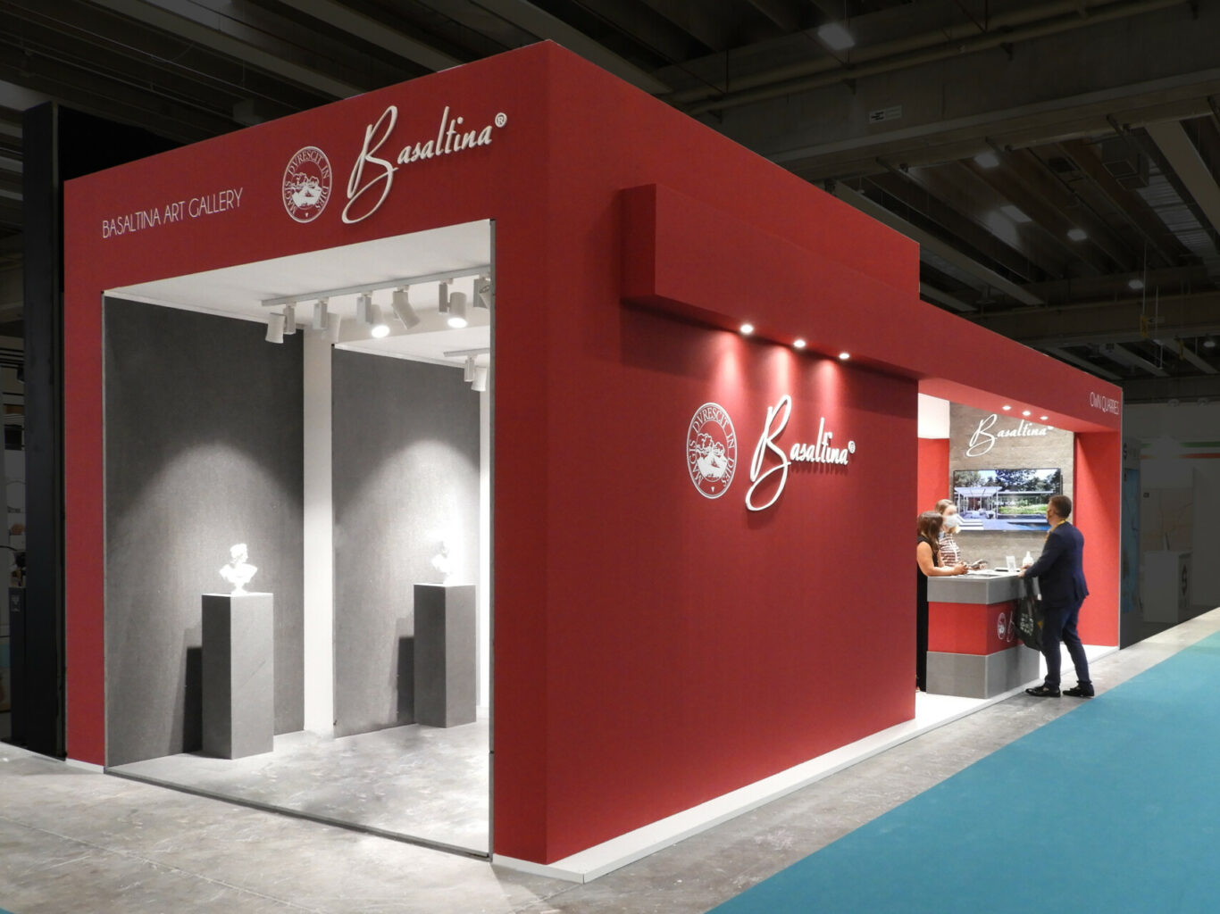 a red and grey booth with people standing in front of it