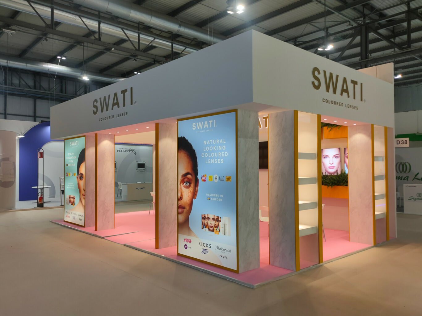 a white and pink booth with signs and posters