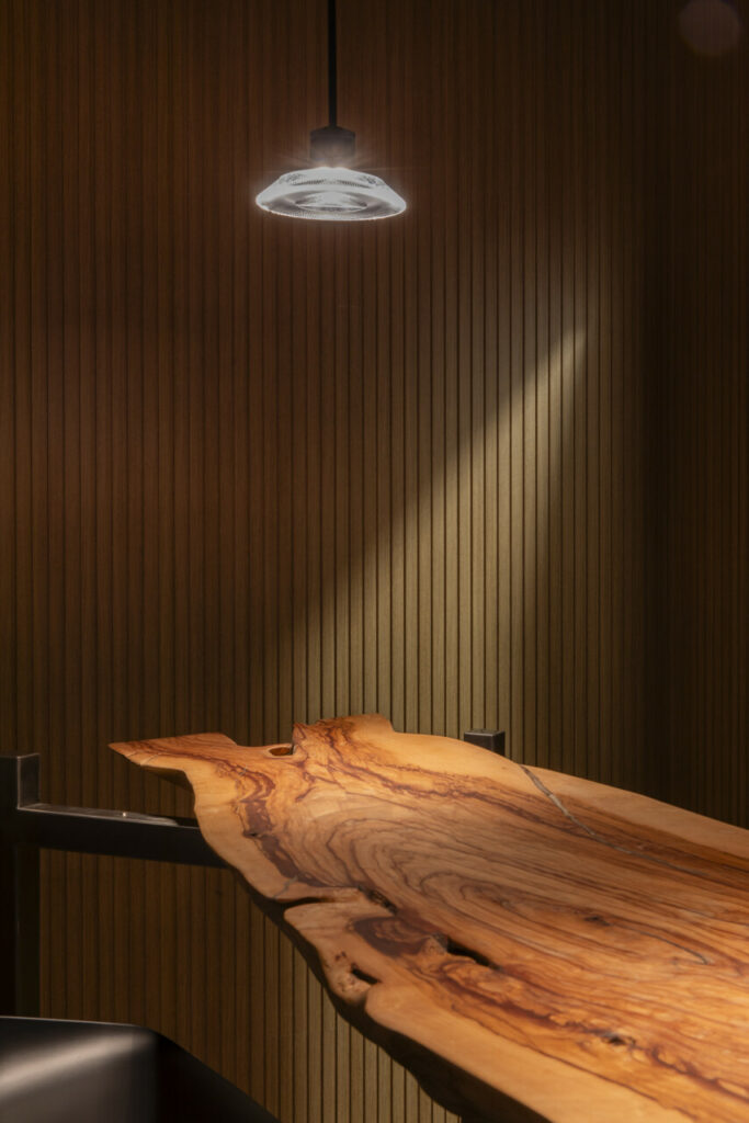 a wooden table with a light on the ceiling