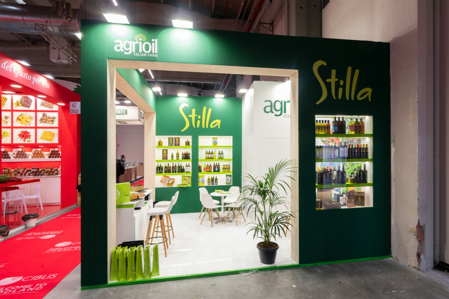 a green and white booth with a plant and a table