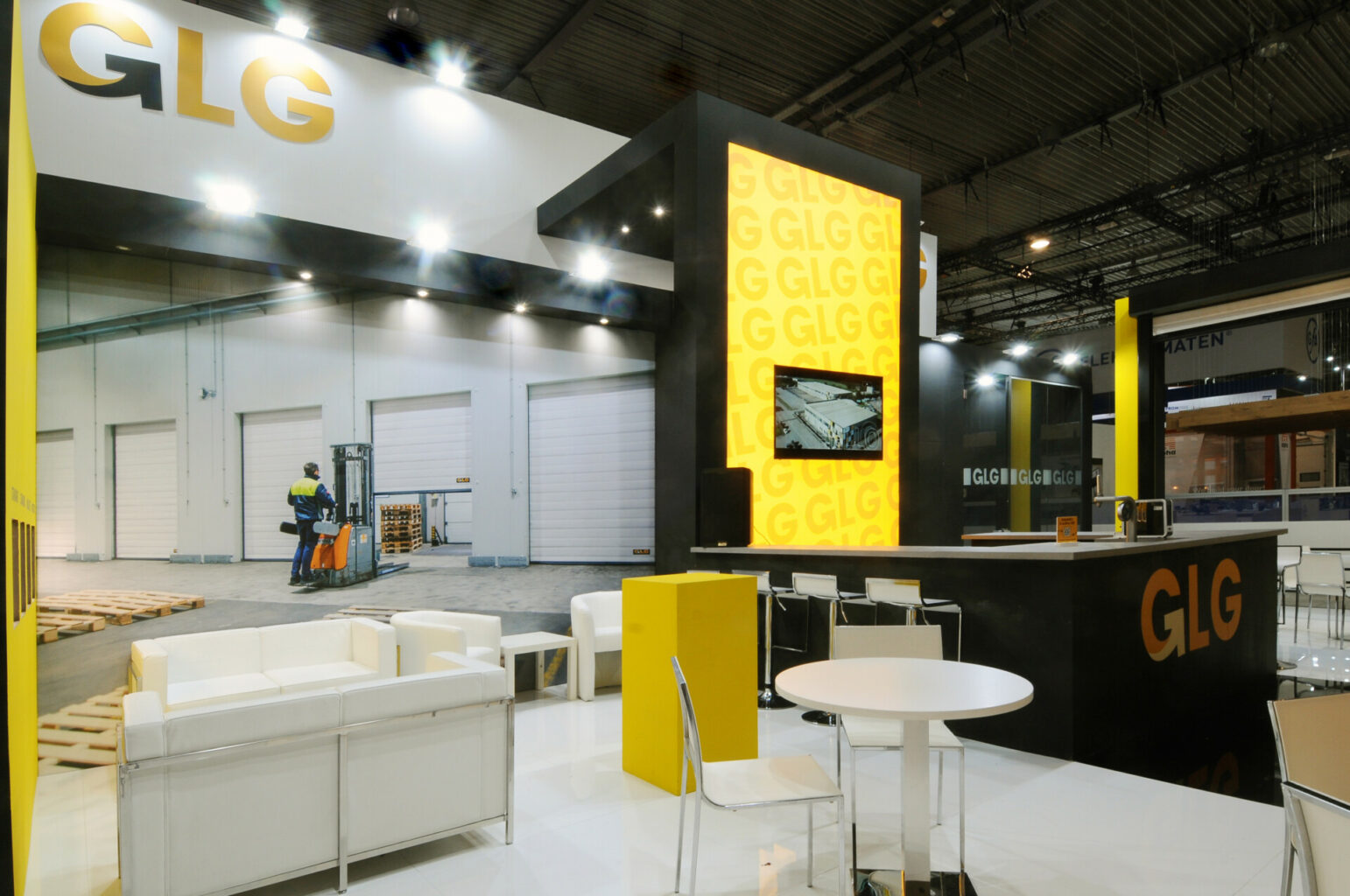 a room with a yellow and black wall and white chairs